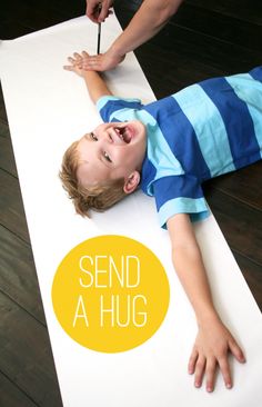 a young boy laying on the ground with his hand up in front of him and an ad that says send a hug