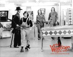 an old black and white photo of people walking in front of televisions on the wall