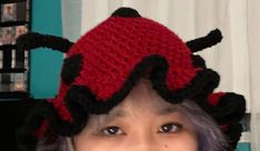 a woman wearing a crocheted lady bug hat