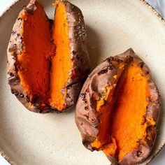 two sweet potatoes on a plate with one cut in half