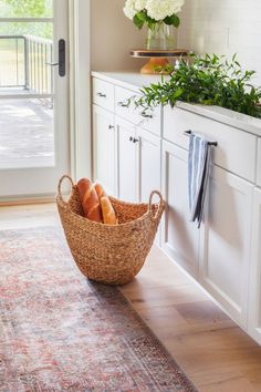 a basket filled with bread sitting on top of a wooden floor next to a door