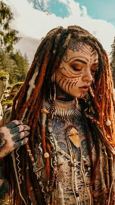 a woman with dreadlocks and tattoos on her face