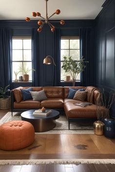 a living room with blue walls and brown leather furniture in the center, along with an orange footstool