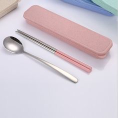 three spoons, two forks and a case on a white table with other items