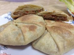 three pita breads on a plate with lettuce