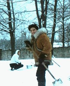 a young man riding skis down a snow covered slope next to another person holding ski poles