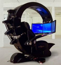 a computer monitor sitting on top of a black object in an empty room with white walls