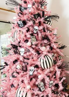 a pink christmas tree decorated with black and white ornaments