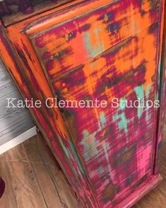 an orange and pink painted cabinet with the words kate clemente studios on it