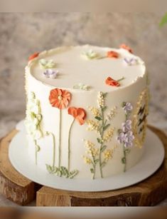 a white cake with orange and purple flowers on it