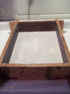 a wooden box sitting on top of a white counter next to a purple cloth covered floor