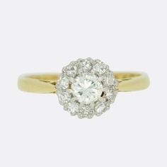 This is a classic round cluster ring set with a halo of single cut round diamonds arranged around the focal, larger single cut diamond. Each stone here is claw set in platinum to emphasise its noticeability whilst the band is crafted in 18ct yellow gold.  Condition: Used (Very Good) Weight: 2.8 grams Size: L 1/2 (52 3/4) Resizable: Yes Face Dimensions: 8mm x 8mm Total Diamond Carat Weight: Approx. 0.55 carats Diamond Details: Colour: G-H, Clarity: SI1 Gold Tested As: 18ct Gold Box: The Vintage J Classic Platinum Cluster Halo Ring, Classic Cluster Diamond Ring With Center Stone, Classic Diamond Cluster Ring With Center Stone, Classic Halo Ring With Brilliant Cluster Cut, Classic Cluster Halo Ring For Anniversary, Classic Cluster Diamond Ring With Brilliant Cut, Classic Cluster Ring With Center Stone, Classic Brilliant Cut Cluster Diamond Ring, Classic White Cluster Ring With Center Stone