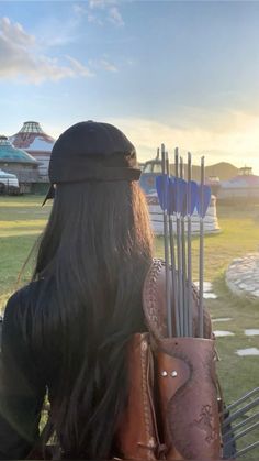 a woman with long black hair holding two arrows