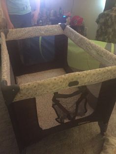 a baby's crib in the middle of a room with a person standing next to it