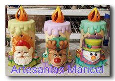 three colorful candles with santa claus and snowman faces