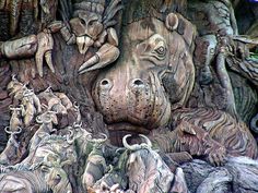 an animal sculpture is shown in front of a tree