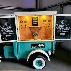 an old fashioned ice cream truck is parked in a garage with its doors open and lights on