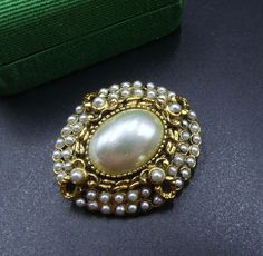 Vintage gold tone and faux pearl cabochon oval shape pin brooch, In good vintage condition, Dates 70's. It's 1"3/8 x 1"1/8, Faux cabochon 17 mm x 13 mm. Thanks. Classic Oval Gold Brooches, Classic Gold Oval Brooches, Classic Gold Oval Brooch, Luxury Oval Cabochon Brooch, Antique Gold Brooches With Oval Cabochon, Vintage Oval Gold Brooches, Antique Gold Brooch With Oval Cabochon, Antique Gold Oval Cabochon Brooches, Vintage Oval Cabochon Brooch