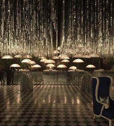 an elegant dining room with chandeliers hanging from the ceiling and chairs in front of it