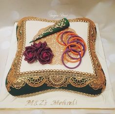 there is a cake that looks like it has been decorated with gold and red ribbons