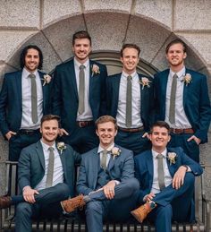 a group of men in suits and ties posing for a photo together on a bench