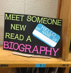 a sign that says, meet someone new read a biography book on top of a bookshelf