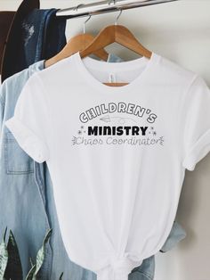 a t - shirt that says children's ministry on it hangs next to some denim jackets