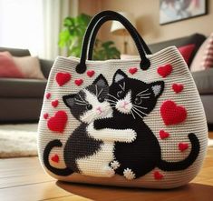 a purse with two cats on it sitting on the floor