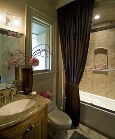 a bathroom with a sink, toilet and bathtub next to a window in it