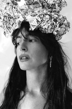 black and white photograph of a woman wearing a hat made out of aluminum foils