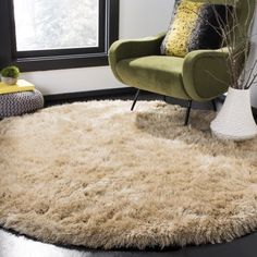 a green chair sitting on top of a black floor next to a white round rug