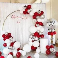 the balloon arch is decorated with red, white and silver balloons for an anniversary celebration