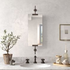 a bathroom with marble counter tops and white walls, including a mirror above the sink