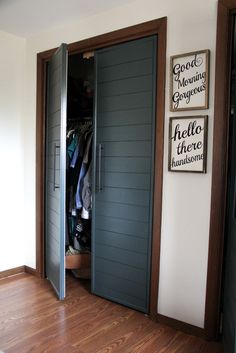 an open closet with clothes hanging on the wall and two doors that lead to another room