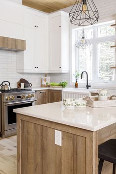 a kitchen with an island in the middle of it and a stove top oven on the other side