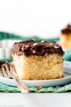 a piece of cake with chocolate frosting and sprinkles on a plate