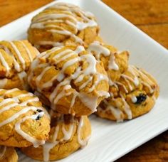 a white plate topped with cookies covered in icing on top of a wooden table