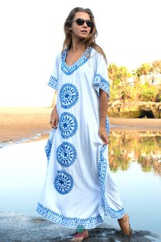 Step out in luxury with our Shu-Shi Embroidered Long Kaftan Dress. This unique maxi caftan dress features gorgeous embroidery, a flattering V-neck, and short sleeves. Perfect for resortwear or boho-chic style, this dress will be sure to make you the life of the party. Made from a lightweight fabric and detailed with intricate designs, this dress will be a luxurious addition to your wardrobe. Bohemian V-neck Maxi Dress For Resort, Embroidered Kaftan For Beach Cover-up, Bohemian Cotton Cover-up For Beach Party, Embroidered Maxi Dress For Summer Vacation, Hippie V-neck Beach Tunic, Beach Hippie V-neck Tunic, Summer Vacation Embroidered Maxi Dress, Long Boho Dress For Beach Cover-up, Embroidered Long Kaftan For Beach