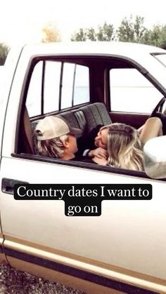 two women sitting in the back of a pick up truck with their heads sticking out