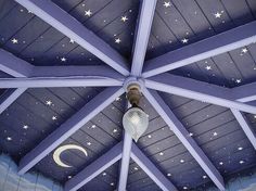 the inside of a blue tent with stars and moon decorations on it's ceiling