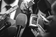 a group of people holding cell phones in front of microphones and talking to each other