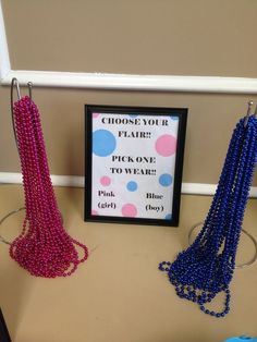 three necklaces are hanging on a rack next to a sign