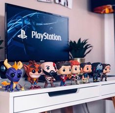 a bunch of figurines sitting on top of a table next to a television