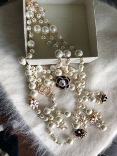 a box with some pearls on it and a necklace in the shape of a flower