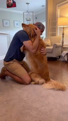 a man is hugging his dog on the floor