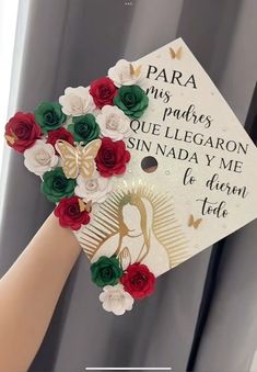 a hand holding a graduation cap with red and green flowers on it that says, para miss padres que legaron sinada y me de diferen tod