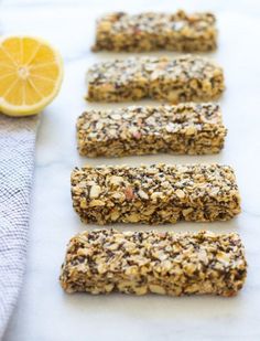 several bars are lined up on a table with lemon wedges next to the bars