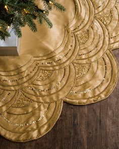 gold placemats on wooden floor with christmas tree