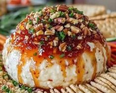 a cheese ball covered in toppings on top of crackers