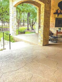 an outdoor patio with stone pillars and arches